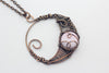 handmade circular pendant with copper wire wrapping and pink fused glass accent