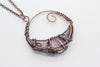 handmade circular pendant with copper wire wrapping and pink fused glass accent