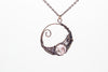 handmade circular pendant with copper wire wrapping and pink fused glass accent
