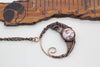 handmade circular pendant with copper wire wrapping and pink fused glass accent