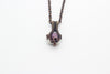 Small handmade pendant with purple and white fused glass and copper wire wrapping