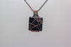 handmade pendant with glittery black fused glass and copper wire wrapping