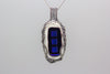 large handmade statement pendant with bright blue, black and white fused glass and silver wire wrapping