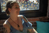 woman in a cafe wearing a handmade copper tree of life and fused glass pendant